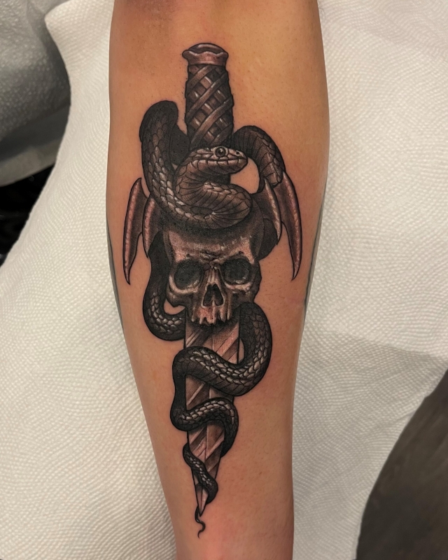 Skull and dagger tattoo with an asp forearm tattoo done in black and grey ink by Shaine Smith of Sacred Mandala Studio.