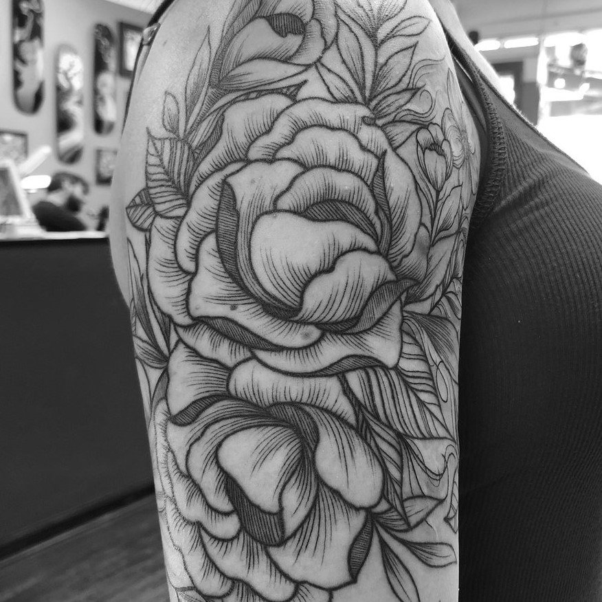 Black and grey fine line flower bicep tattoo of peonies.