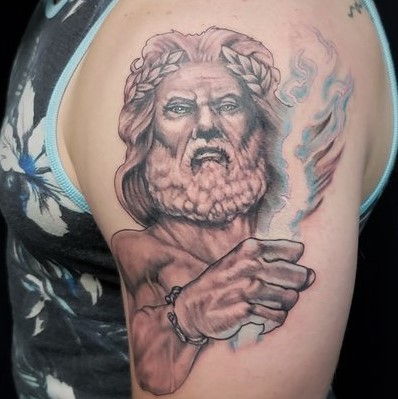 Tattoo of Zeus with a blue lightening bolt on shoulder and bicep done in partial color at Sacred Mandala Studio in Durham, NC.
