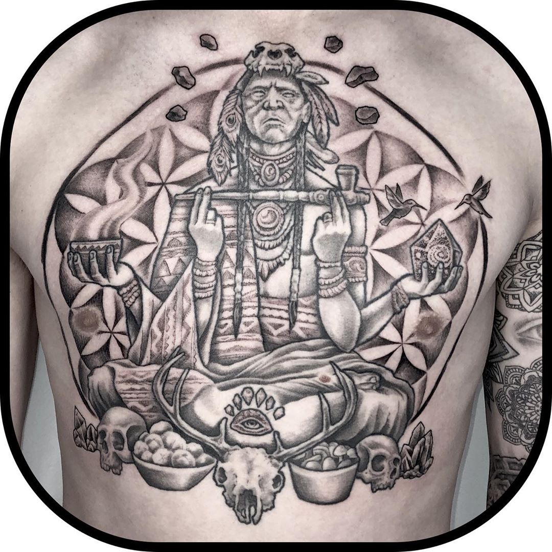 Full back in black and white with Native American holding a peace pipe. Book a custom tattoo with Chris at Sacred Mandala Studio - Durham, NC.