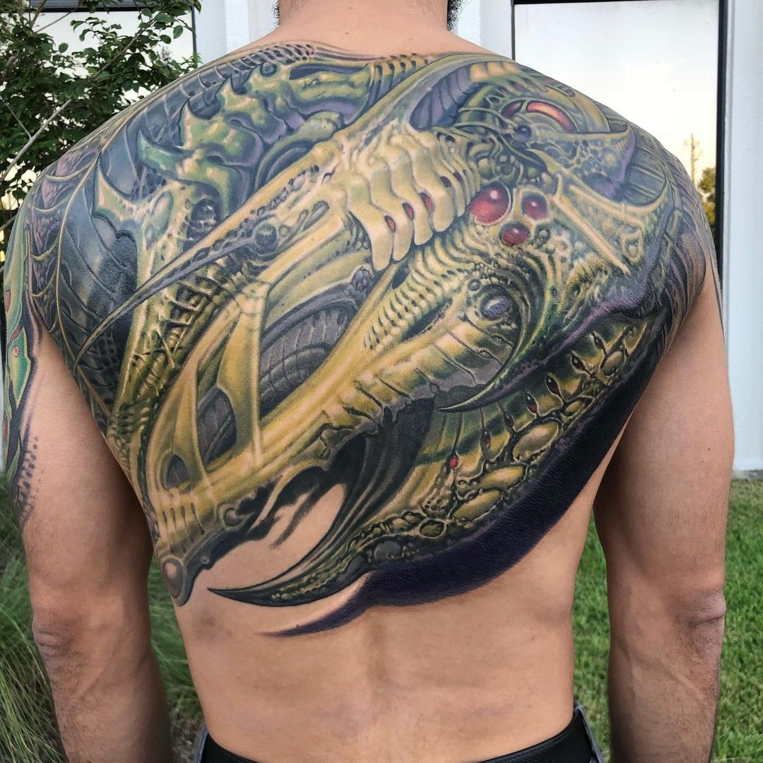 Full color back tattoo of a dragon curled up with razor wings - biotech.