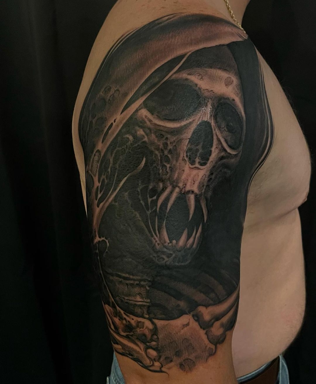 Skull head with fangs in cowl - fine line black and grey upper arm and shoulder tattoo by tattoo artist Shaine Smith.