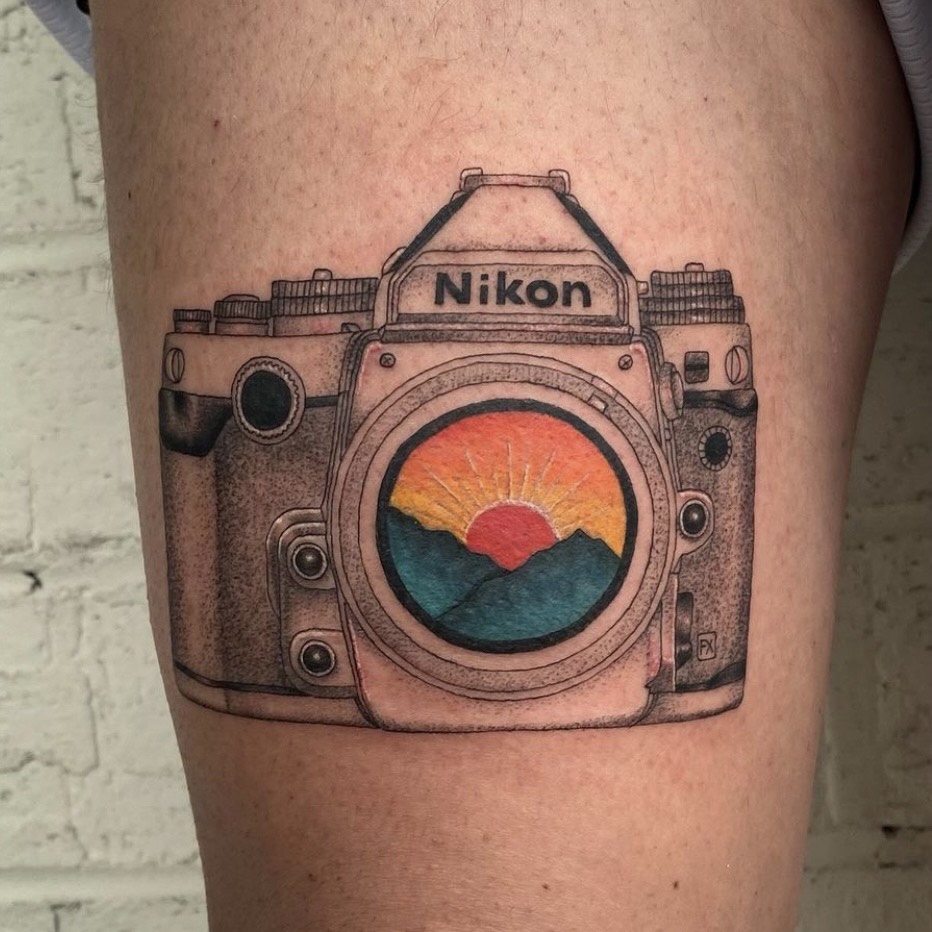 Black and grey camera and football tattoo located on