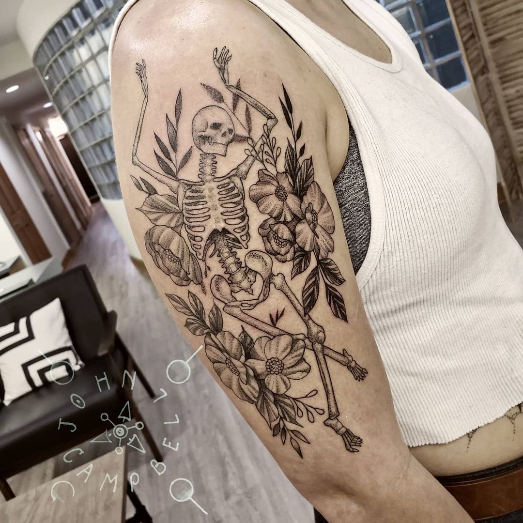John Campbell black and grey fine line tattoo of a skull dancing in flowers. Book a custom tattoo with John at Sacred Mandala Studio - Durham, NC.