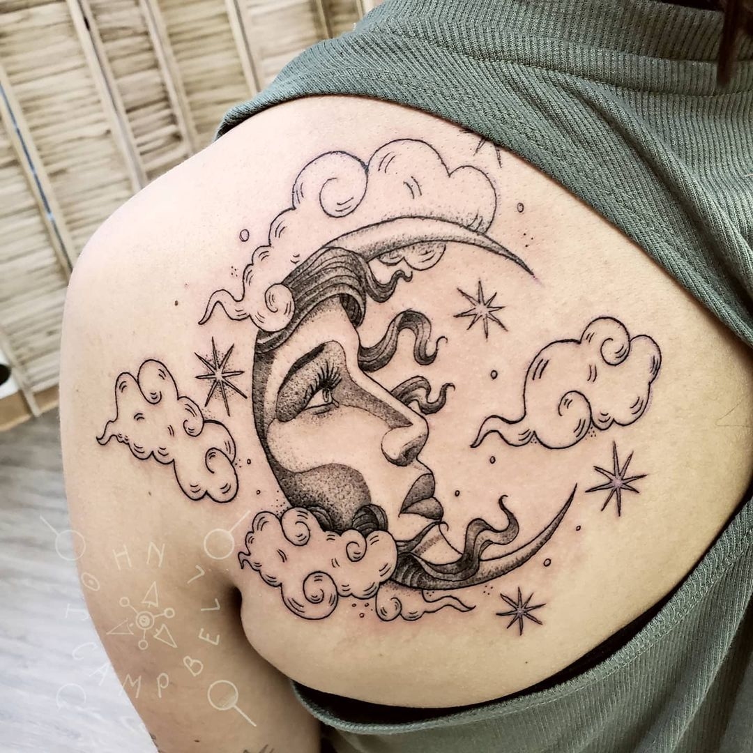 John Campbell black and grey fine line tattoo of a woman's face in the moon with stars and clouds. Book a custom tattoo with John at Sacred Mandala Studio - Durham, NC.